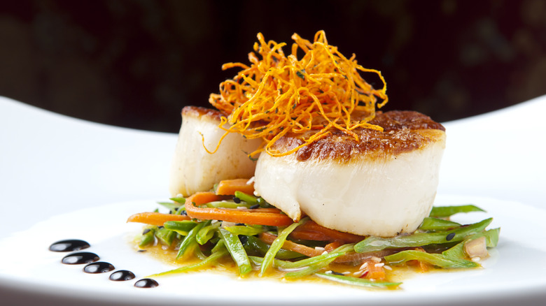 seared scallops on a bed of vegetables