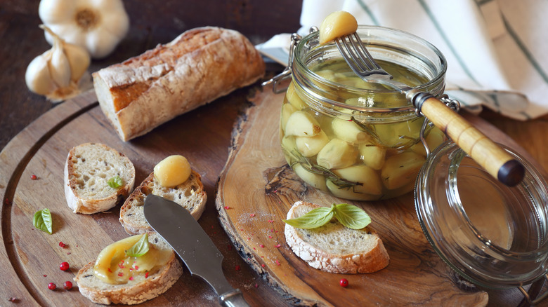 A jar of garlic confit with slices of bread