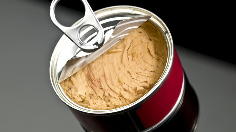 open can of tuna on a black surface