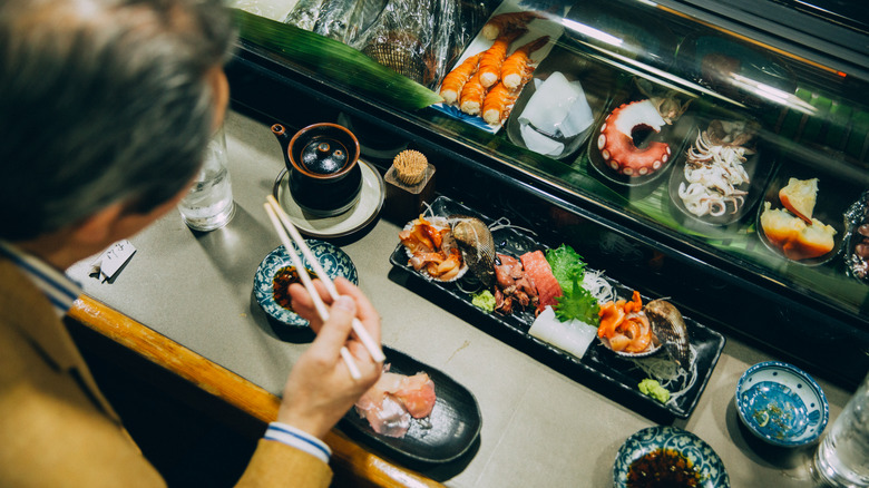 man eating at a sushi counter