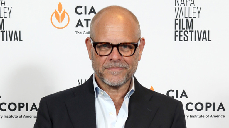 Alton Brown smiling and wearing a suit at the Napa Valley film festival