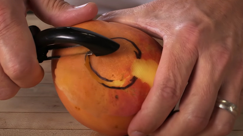 Vegetable peeler peeling mango