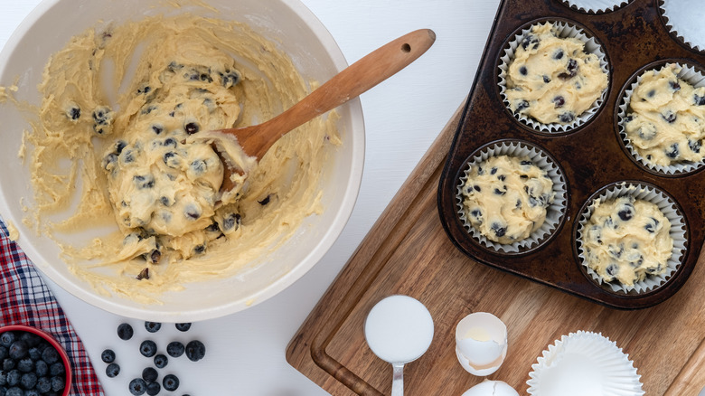 Blueberry muffin batter in bowl and muffin tin