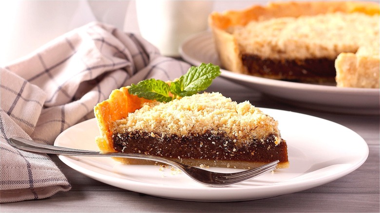 Piece of Shoofly pie and a metal fork on a white plate