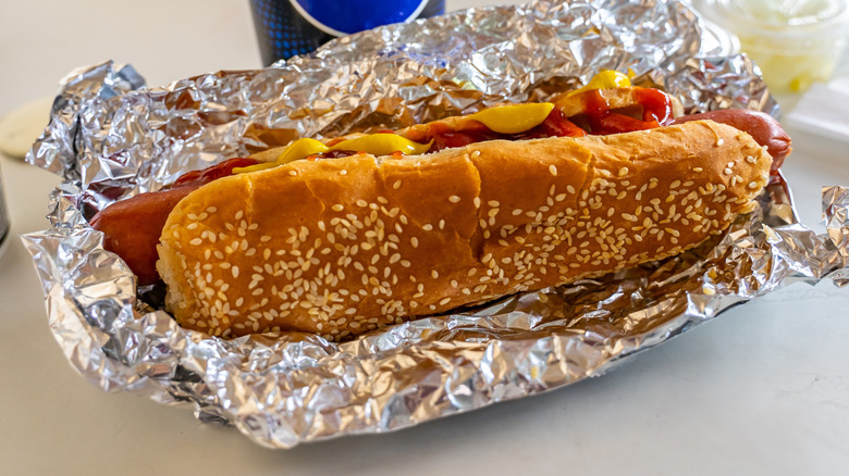 Costco hot dog wrapped in foil next to a Pepsi