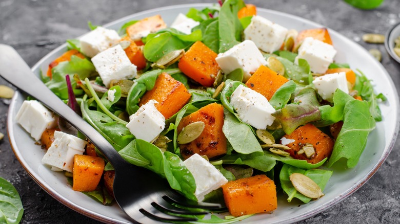Fresh salad with baby greens, seeds, roasted squash, and cheese