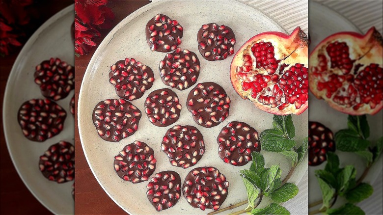 Pomegranate and chocolate candy cups on plate