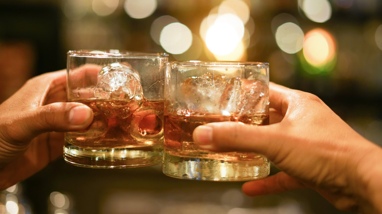 two people clinking glasses with brandy digestif 