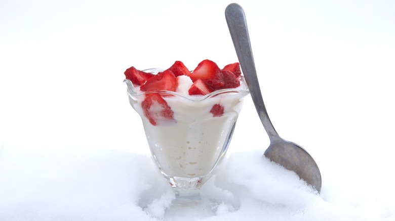 Snow ice cream in dish with strawberries with spoon