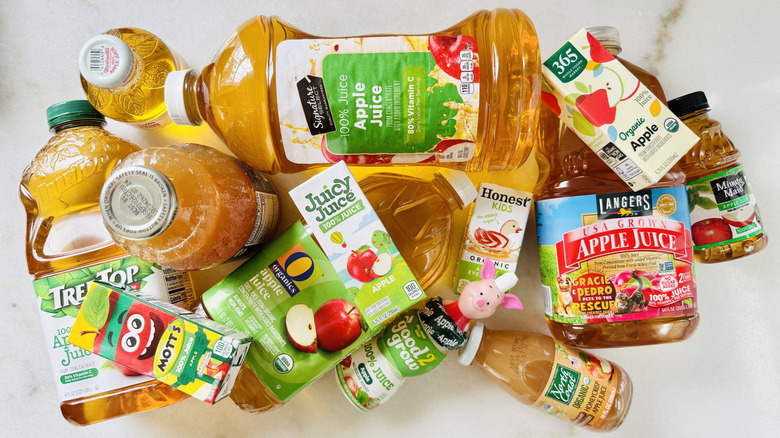 Various store-bought apple juice bottles and boxes