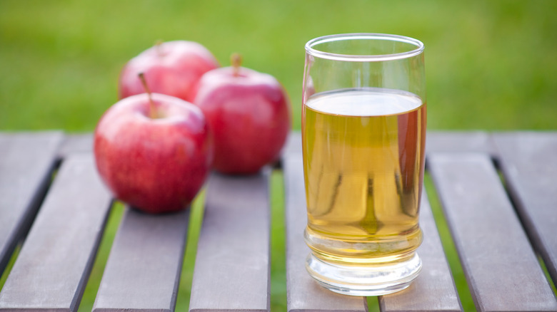 Apple juice in a glass with fresh apples
