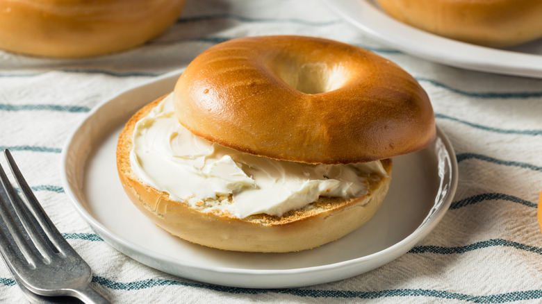 Bagel and cream cheese on plate