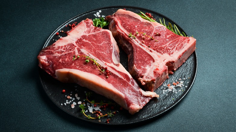 Raw T-bone and porterhouse steaks on a plate 