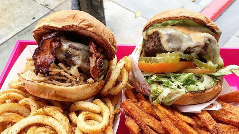burgers with fries on tray