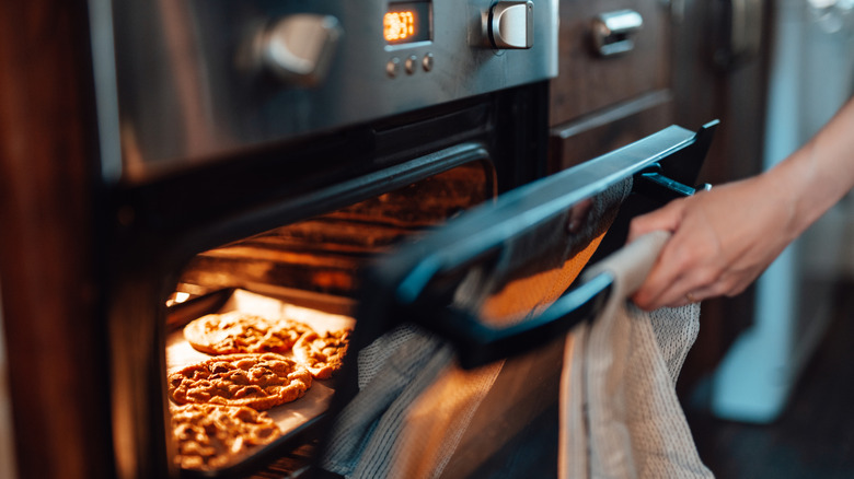 Chef opening an oven door to check on their food