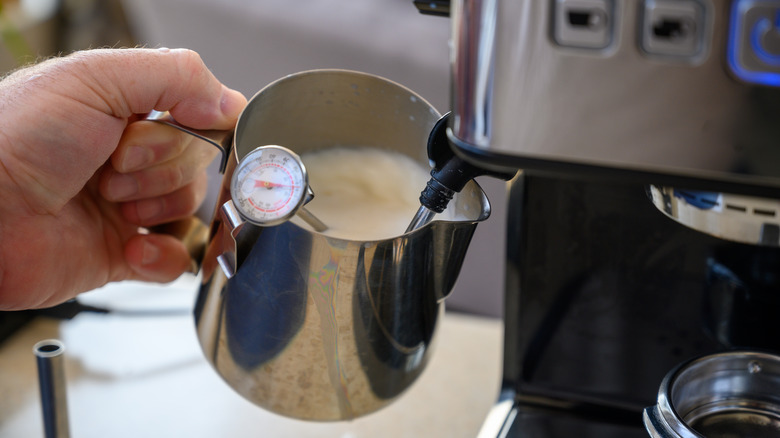 Person steaming milk for a latte