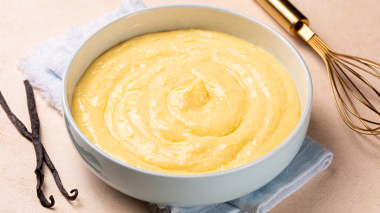 Bowl of pastry cream with whisk and vanilla beans