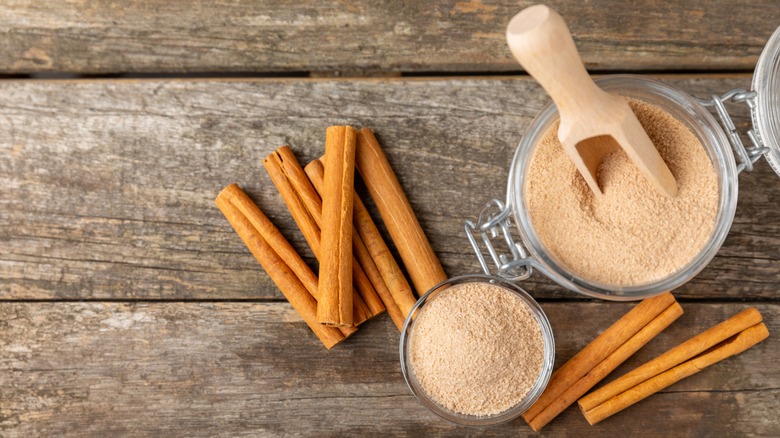 A jar of cinnamon sugar with cinnamon sticks