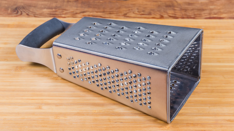 Box grater lying flat on wood board