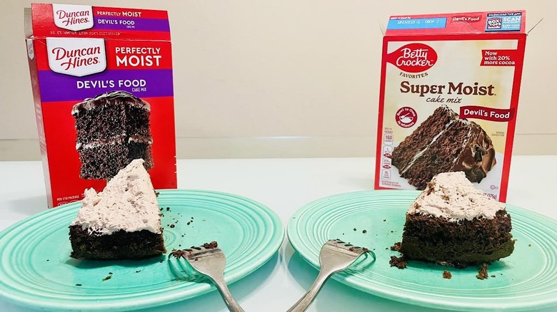 Boxes of Duncan Hines and Betty Crocker cake mixes with frosted slices on green plates