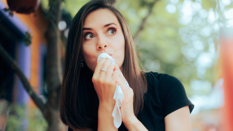 Woman dabs her mouth with a napkin