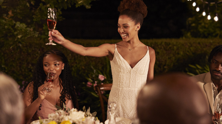 Woman giving toast at upscale dinner outside