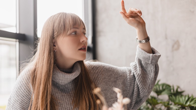 Woman raising a finger to call the server to her table