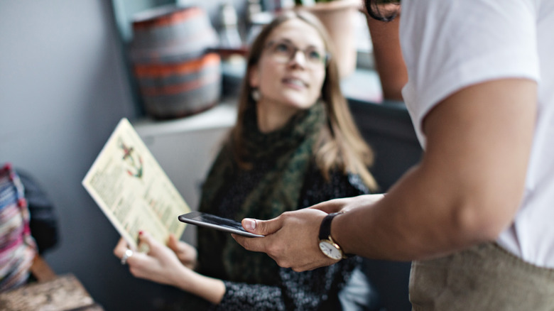 Woman asking a server about the menu