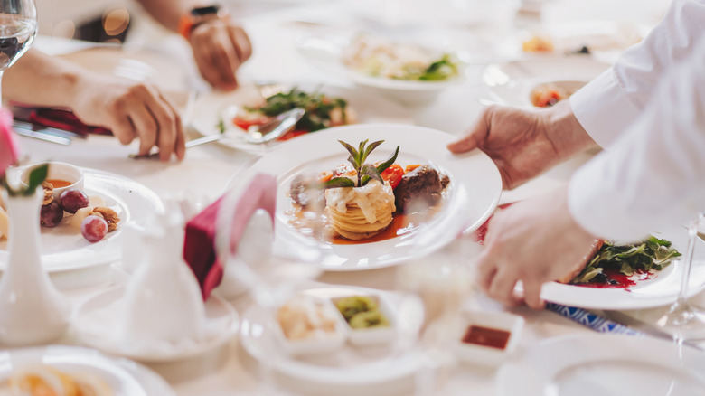 Server placing a plate of food on table