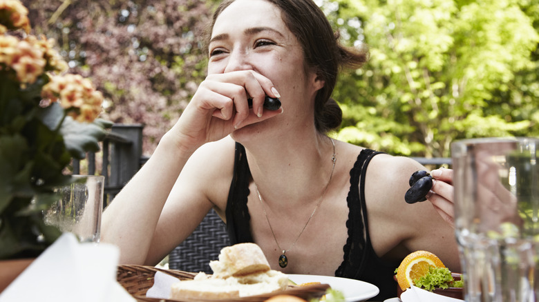 Woman eating grapes at high-end restaurant