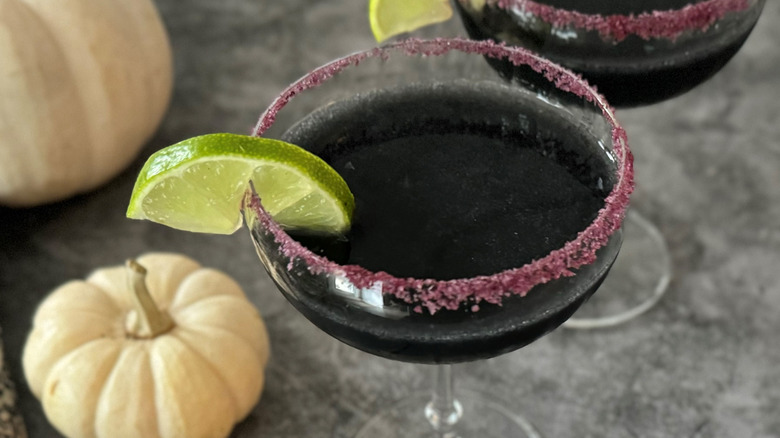 black cocktail with lime wedge