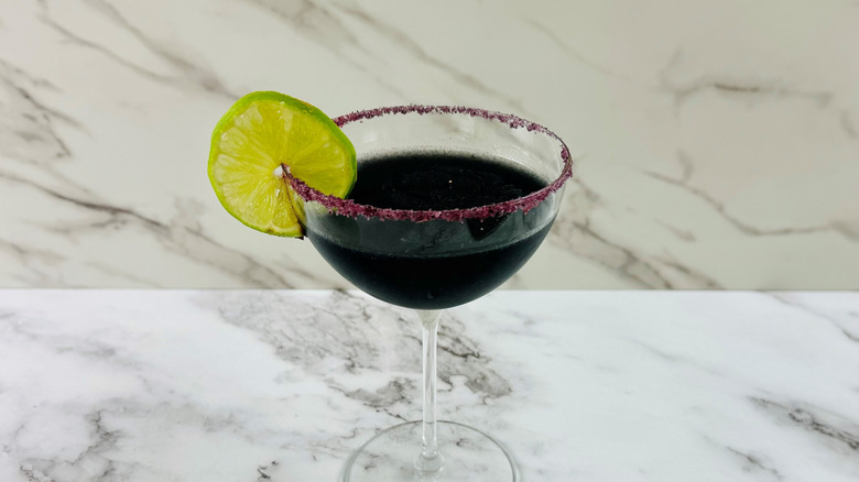 black cocktail with lime wedge