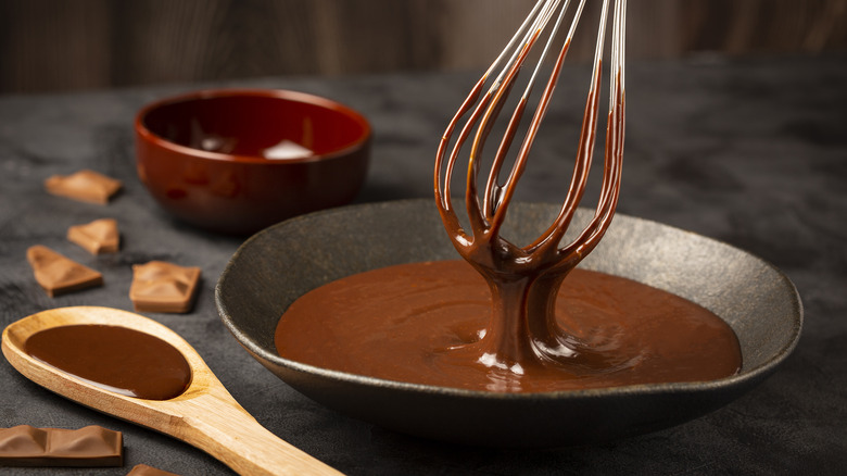 Melted chocolate dripping off whisk