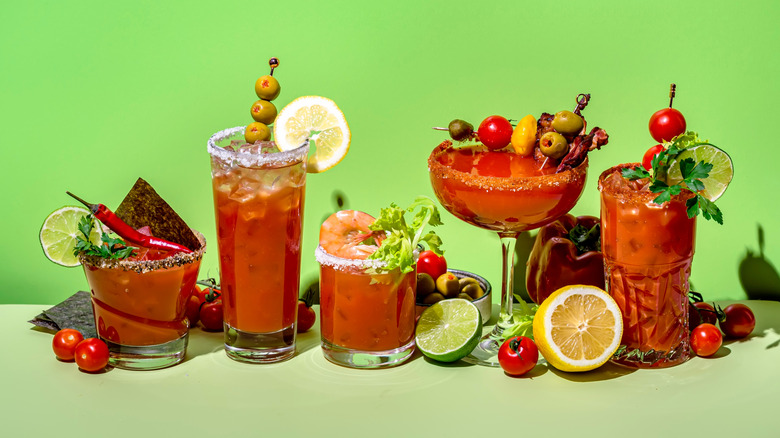 A variety of Bloody Mary cocktails on a green background