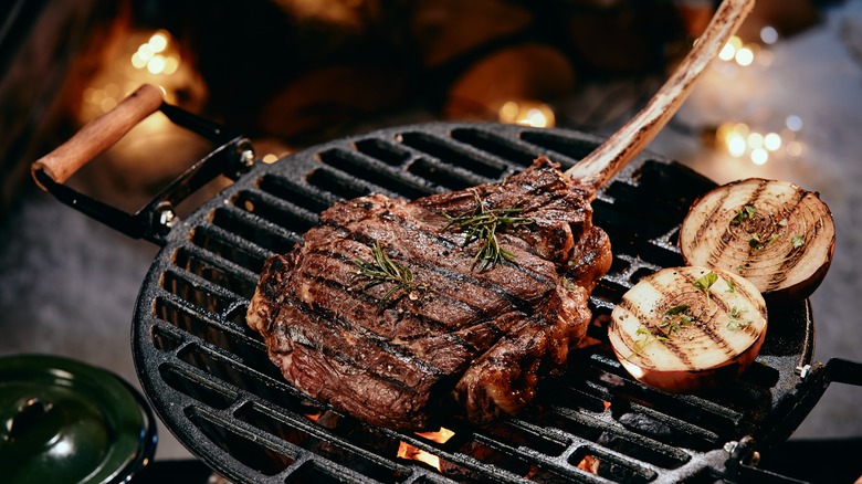 Steak and onions cooking on grill