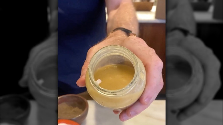 Bobby Flay holding jar of mustard dressing