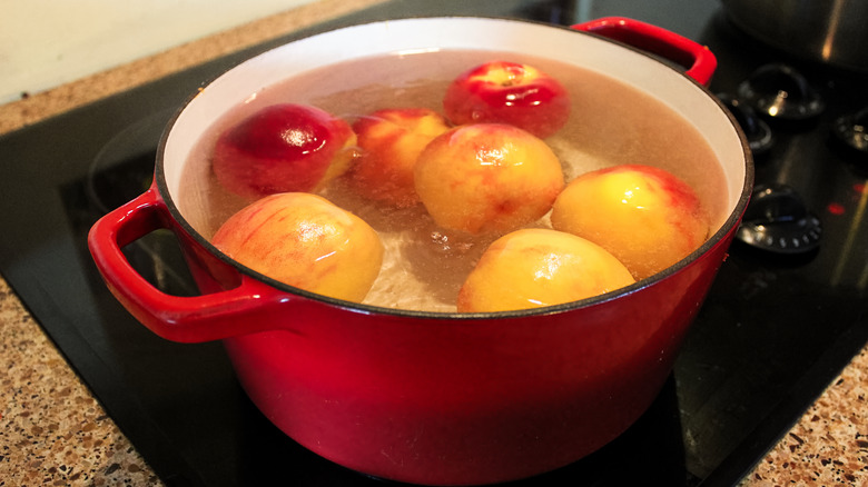 Peaches in a pan of boiling water