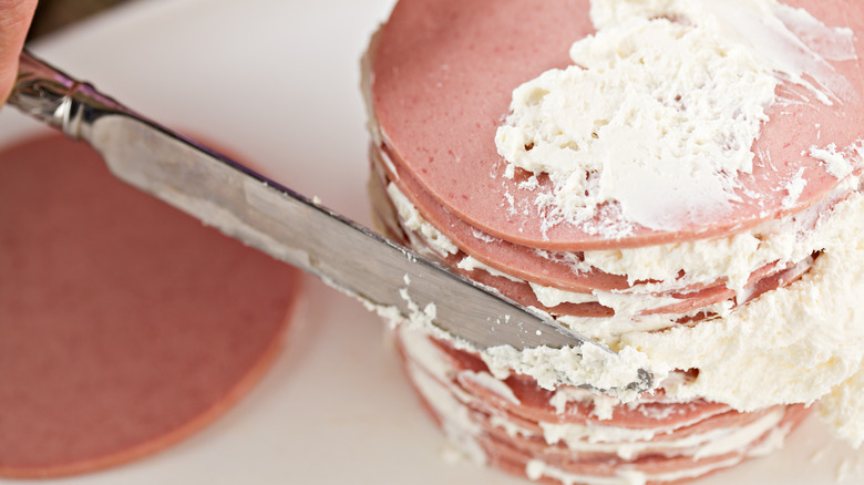 Knife frosting bologna with cream cheese