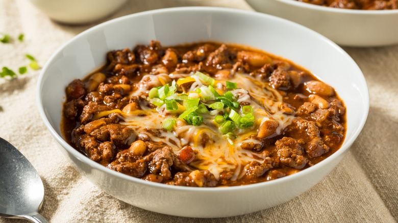 a bowl of turkey chili topped with shredded cheese and green onions