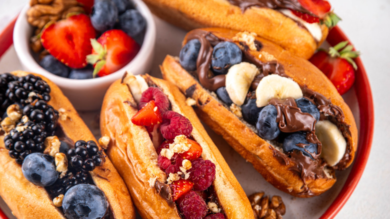 Dessert dogs adorned with fruit and chocolate