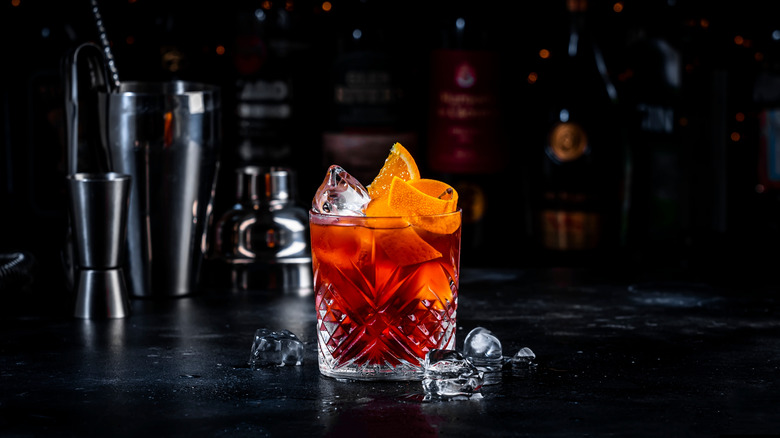 red Negroni on black bar with crushed ice