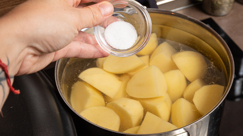 adding salt to potato pot