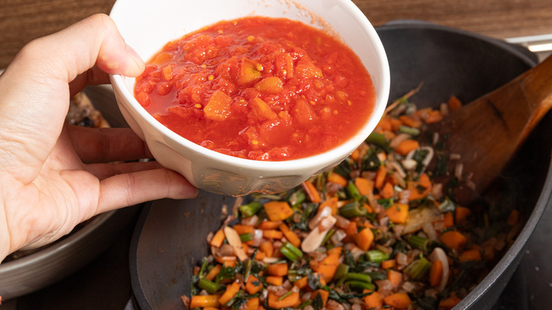 adding tomatoes to braising liquid