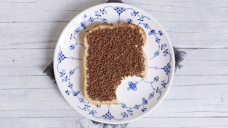 A slice of bread with hagelslag on a plate