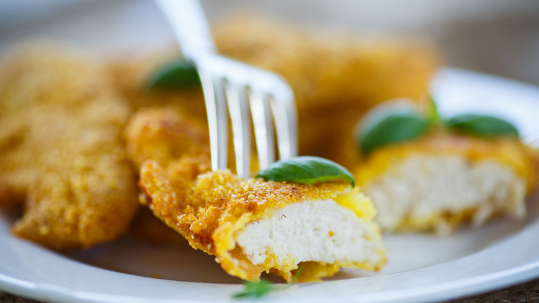 Crispy chicken strips cut in half on plate