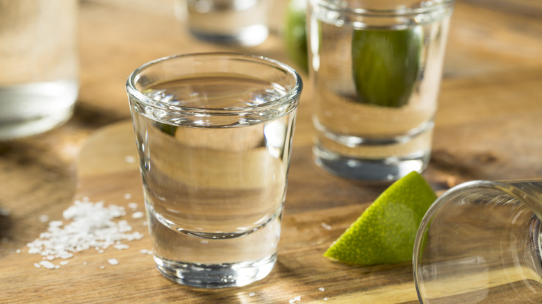 Shot glasses with tequilas and limes