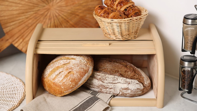 Bread is being stored in a bread box.