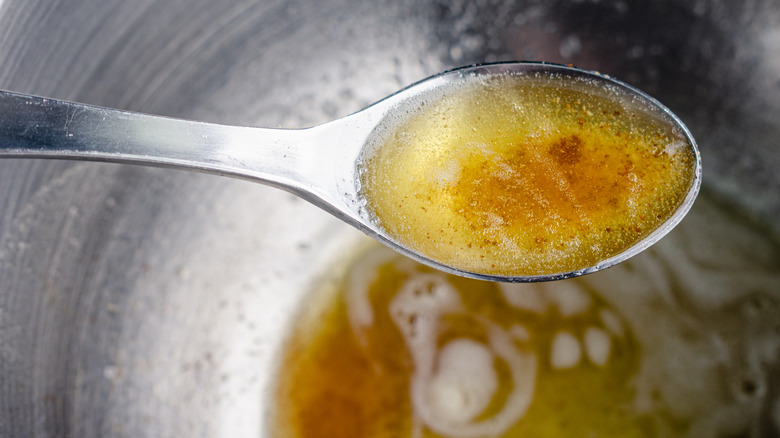 Spoonful of hot brown butter and mixing bowl