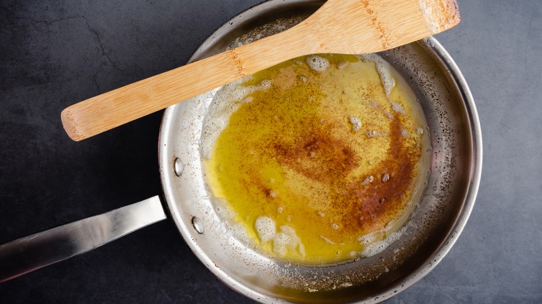 Brown butter in skillet with wooden spatula