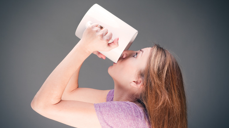 Person drinking a giant cup of coffee